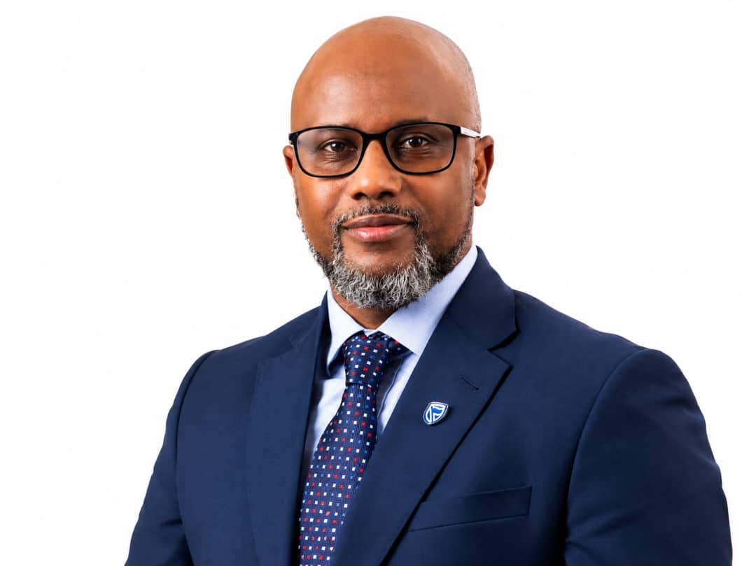 Lesego Osman formal executive portrait in navy suit and glasses.