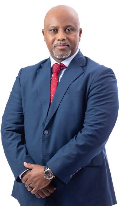 Lesego Osman standing in a navy suit against a white background.